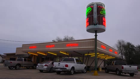 a drive up diner with a giant root beer mug sign rotating