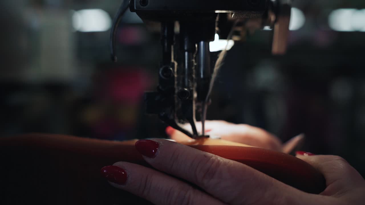 trabajador cosiendo la suela de un zapato a cámara lenta