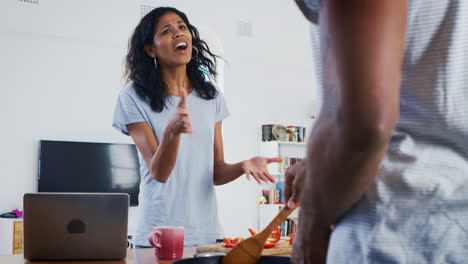 Young-Couple-Preparing-Meal-Together-In-Modern-Kitchen