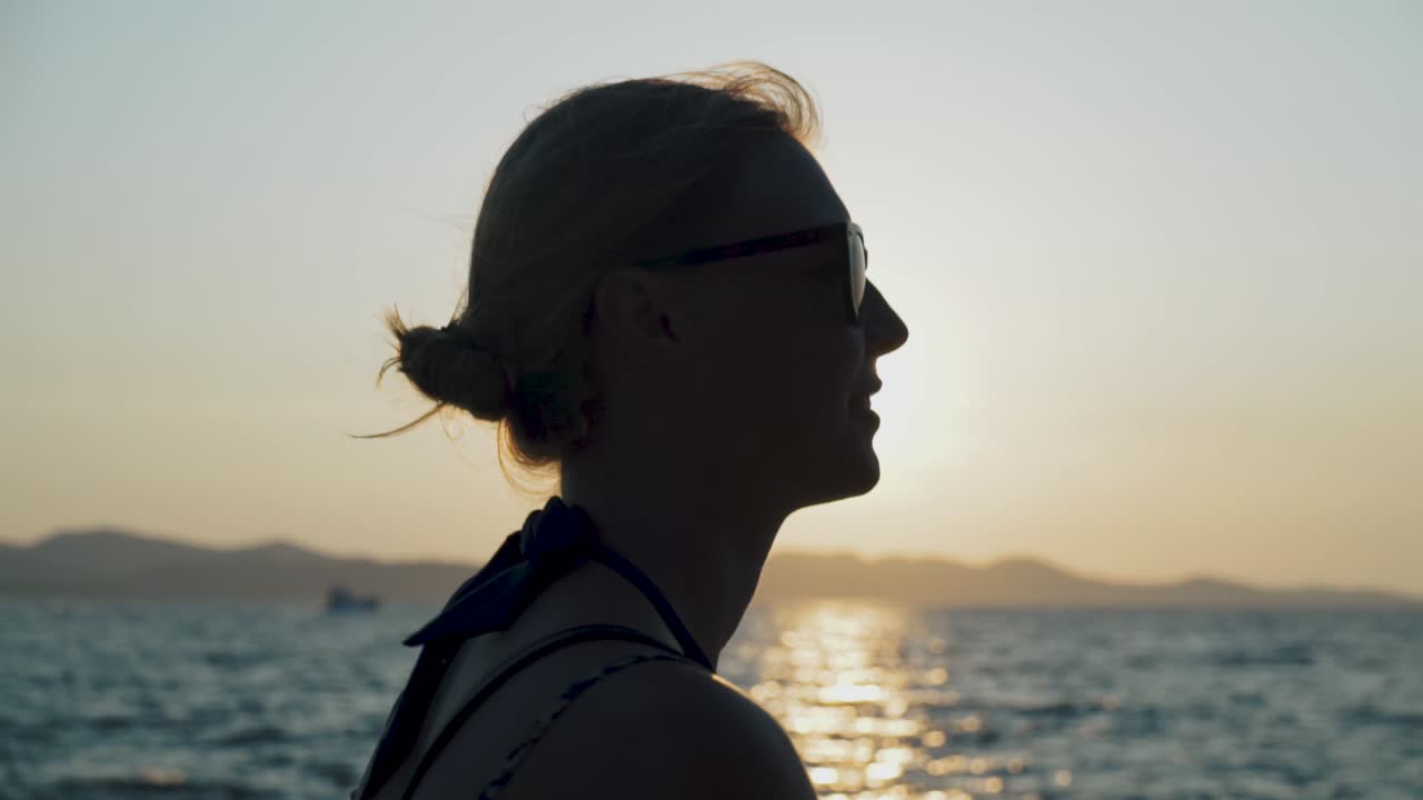 Silhouette of a Woman Watching the Sunset Over the Ocean