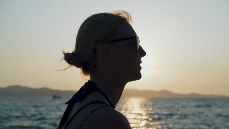 silhouette of a woman watching the sunset over the ocean