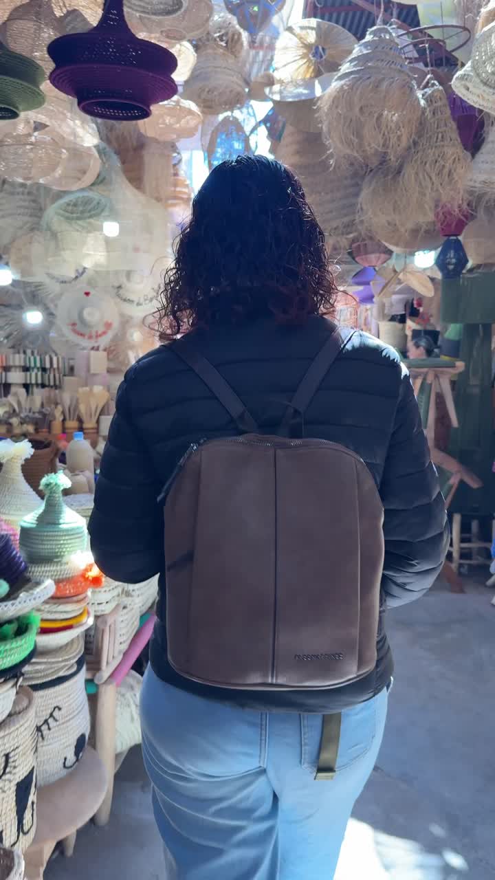 Donna che passeggia in un mercato artigianale tradizionale con creazioni fatte a mano.