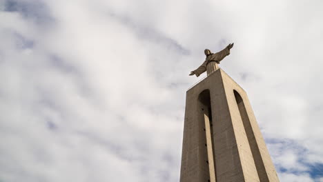 timelapse of the sanctuary of christ the king religious monument with the movement of the clouds in the background in lisbon, portugal