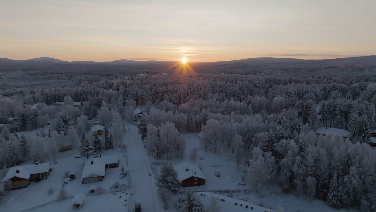 Drone flying over homes on the arctic countryside, winter sunset in Lapland