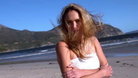 hermosa rubia mirando a la cámara en un día soleado en la playa
