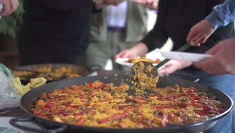 sirviendo paella a una reunión de personas que celebran