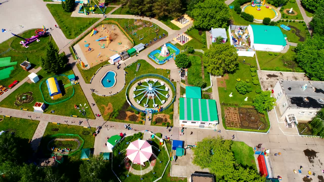 atracciones y patio de recreo en el parque contra la ciudad