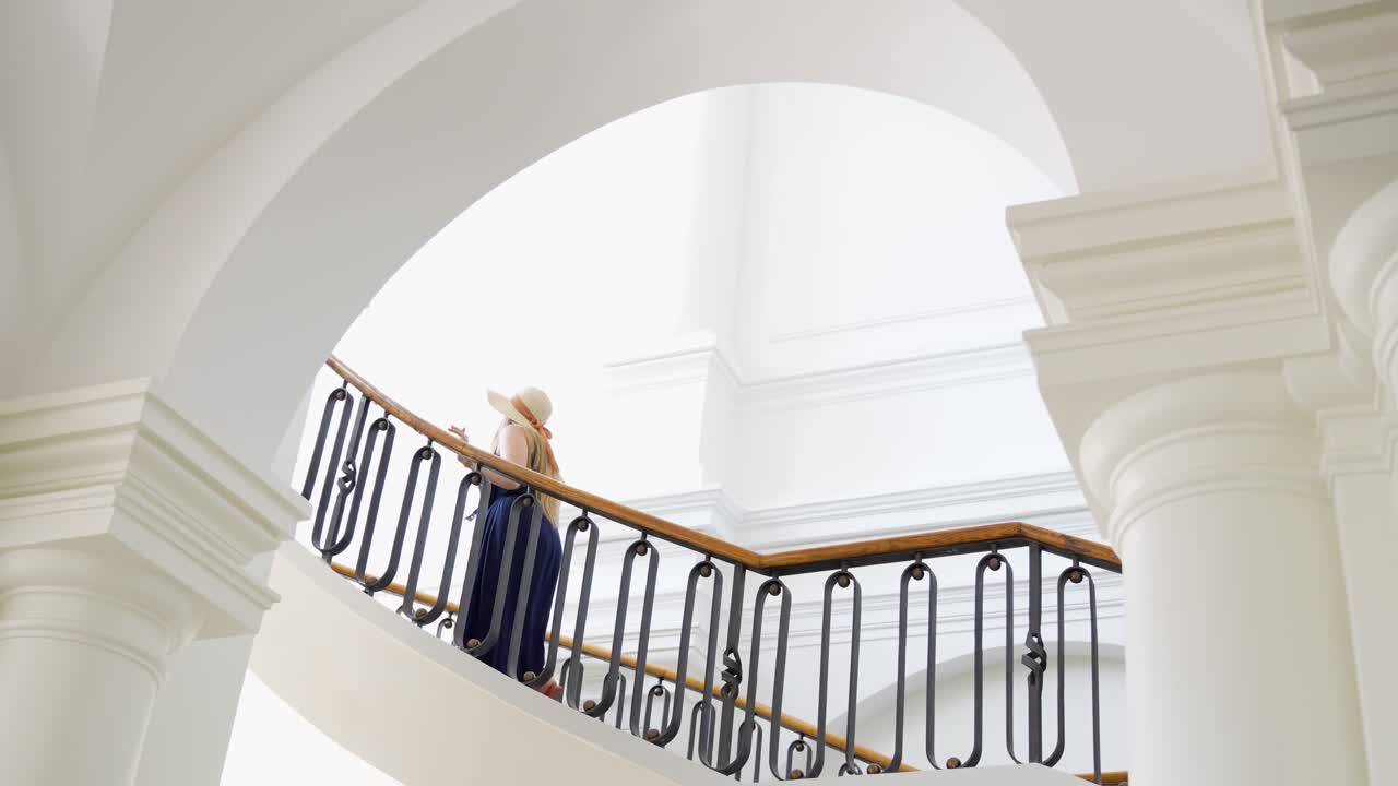 mujer subiendo las escaleras en el palacio de estilo barroco de jelgava