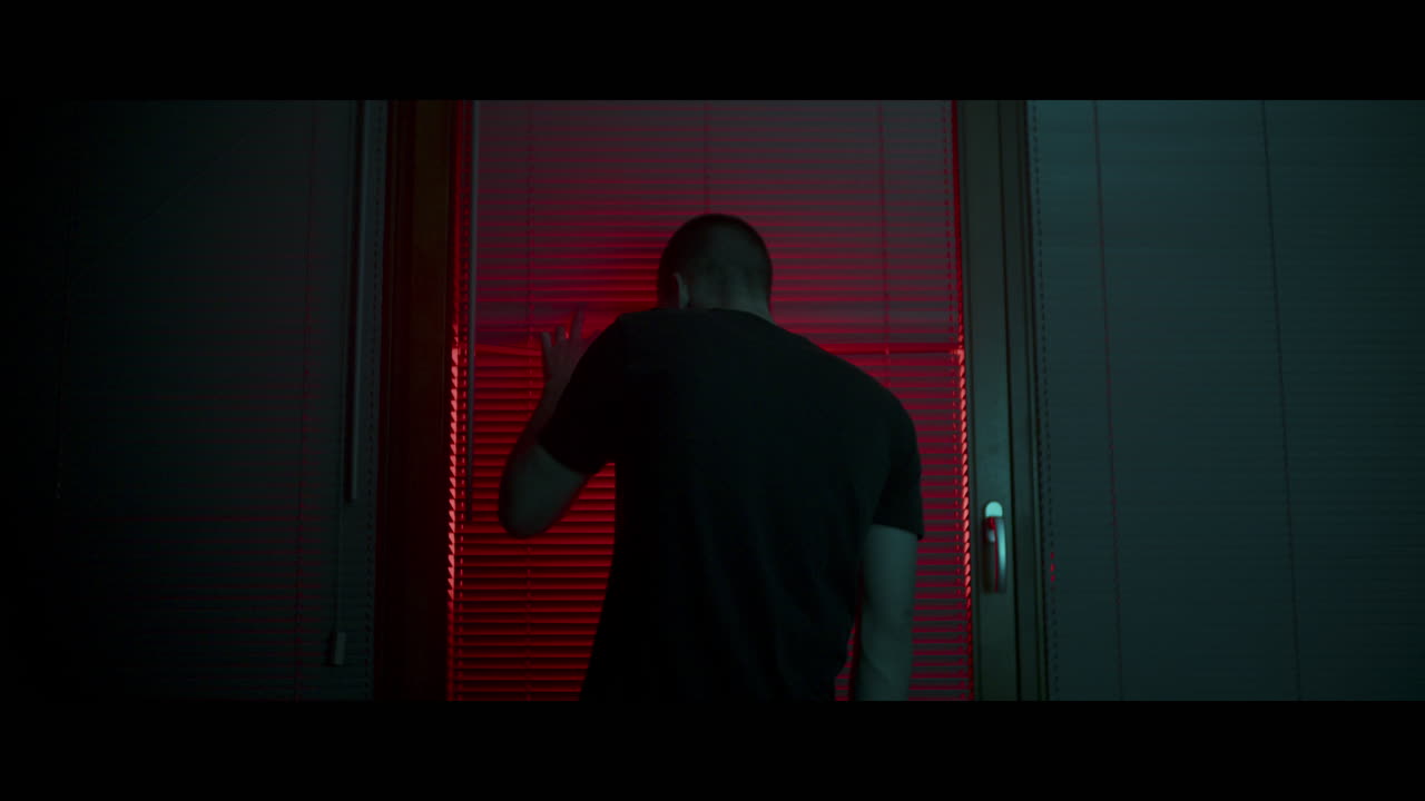 Man Looking Through Window at Night