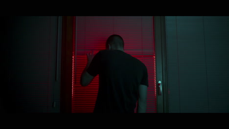 man looking through window at night
