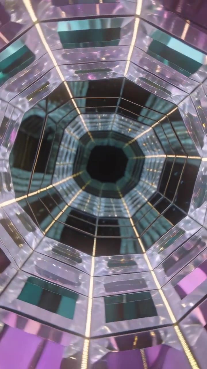 Video verticale: Telecamera che panoramica e si centra in un caleidoscopio, rivelando pannelli a prisma e strisce LED.
