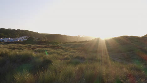 Toma-De-Drone-Del-Hermoso-Sol-Vespertino-Poniéndose-Sobre-Dunas-De-Arena.