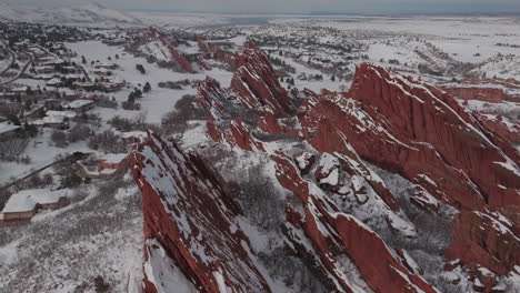 fresh snow sunny bluesky roxborogh state park golf course aerial drone colorado front range winter spring deep powder dramatic sharp red rocks mountain landscape littleton denver backwards pan up