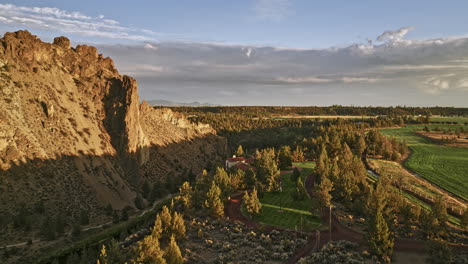 Terrebonne-Oregon-Aerial-v56-fly-around-cliffside-mansion-overlooking-at-Smith-Rock-State-Park-with-Crooked-river-winding-through-the-rock-formations-at-sunset---Shot-with-Mavic-3-Cine---August-2022
