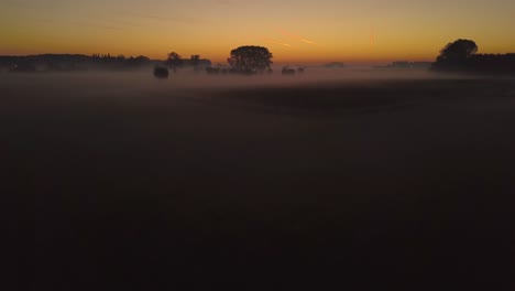 view of sunrise over misty fields