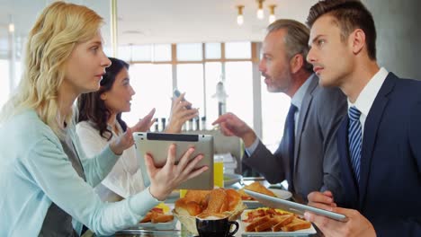 Mujeres-Y-Hombres-De-Negocios-Interactuando-Entre-Sí-Mientras-Usan-Una-Tableta-Digital.