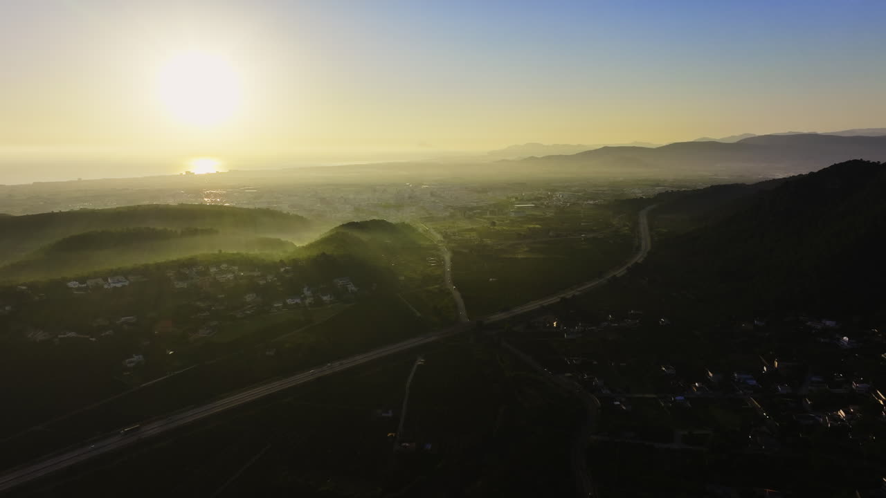 amanecer sobre la ciudad costera y las montañas