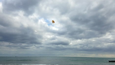 parapente detrás del horizonte del océano y el barco durante un día nublado en méxico