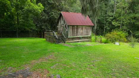 Aerial-reveal-of-small-barn,-old-oak-tree-with-Spanish-Moss-and-house