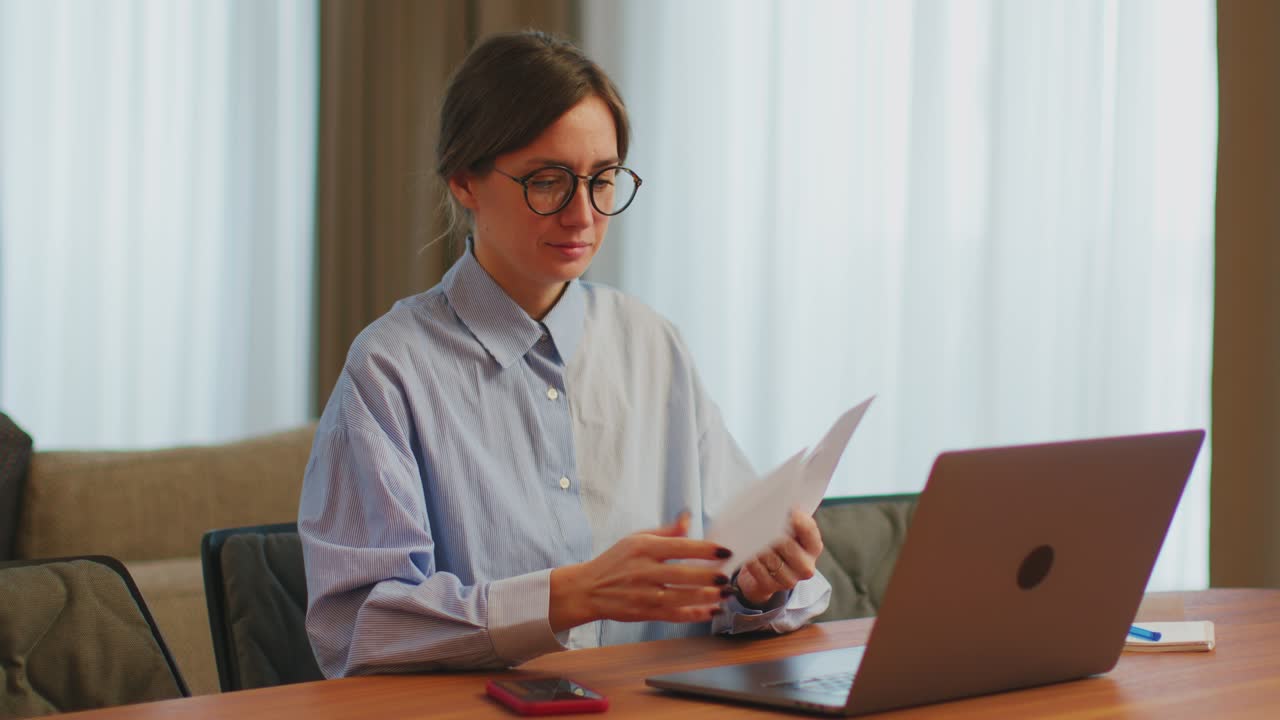 contadora contable que calcula facturas o impuestos, utiliza el teléfono y la computadora portátil, administra los gastos financieros en el escritorio