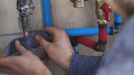 a man sanding down copper pipe with sandpaper