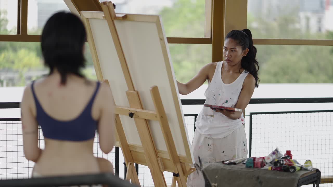 Woman Artist Painting a Model in an Art Studio