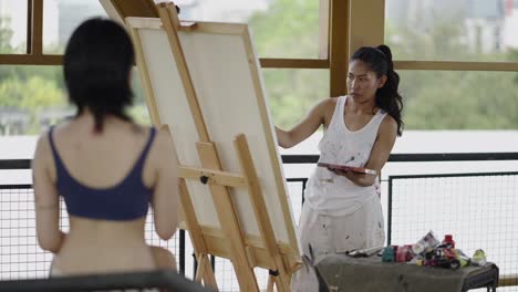woman artist painting a model in an art studio