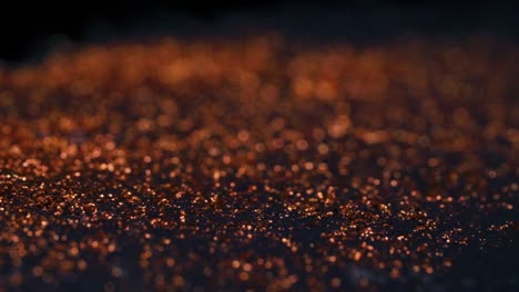 abstract colorful red golden sand organically flows in colorful liquid in macro, black background