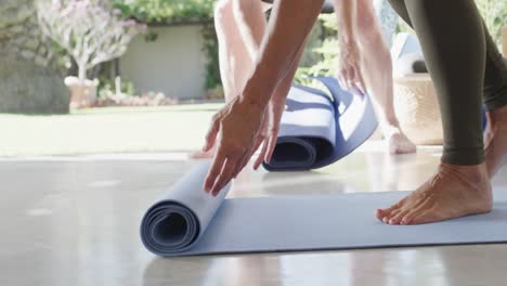 un primer plano de varios ancianos preparando esteras de ejercicio para la clase de pilates, sin alteraciones, en cámara lenta.