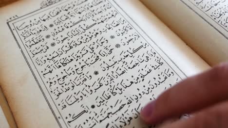 hands turning the pages of the quran reading and browsing the book