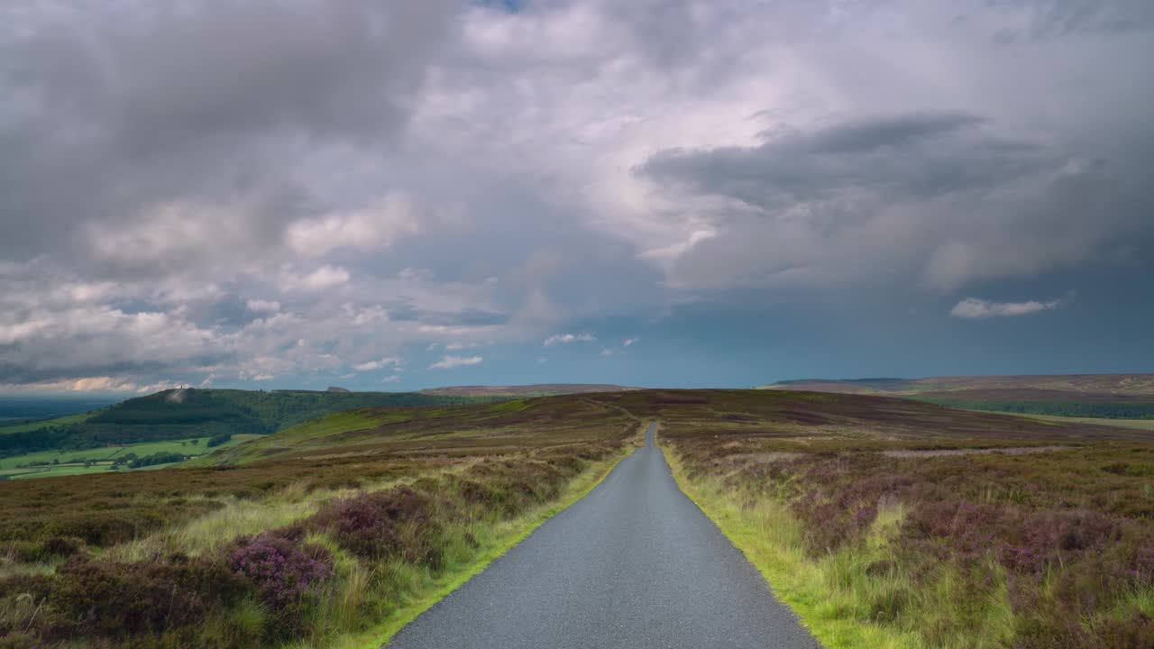 폭풍우 구름이 북요크 무어스 국립공원 (영국) 을 지나가며 히더 꽃이 피고 있습니다.