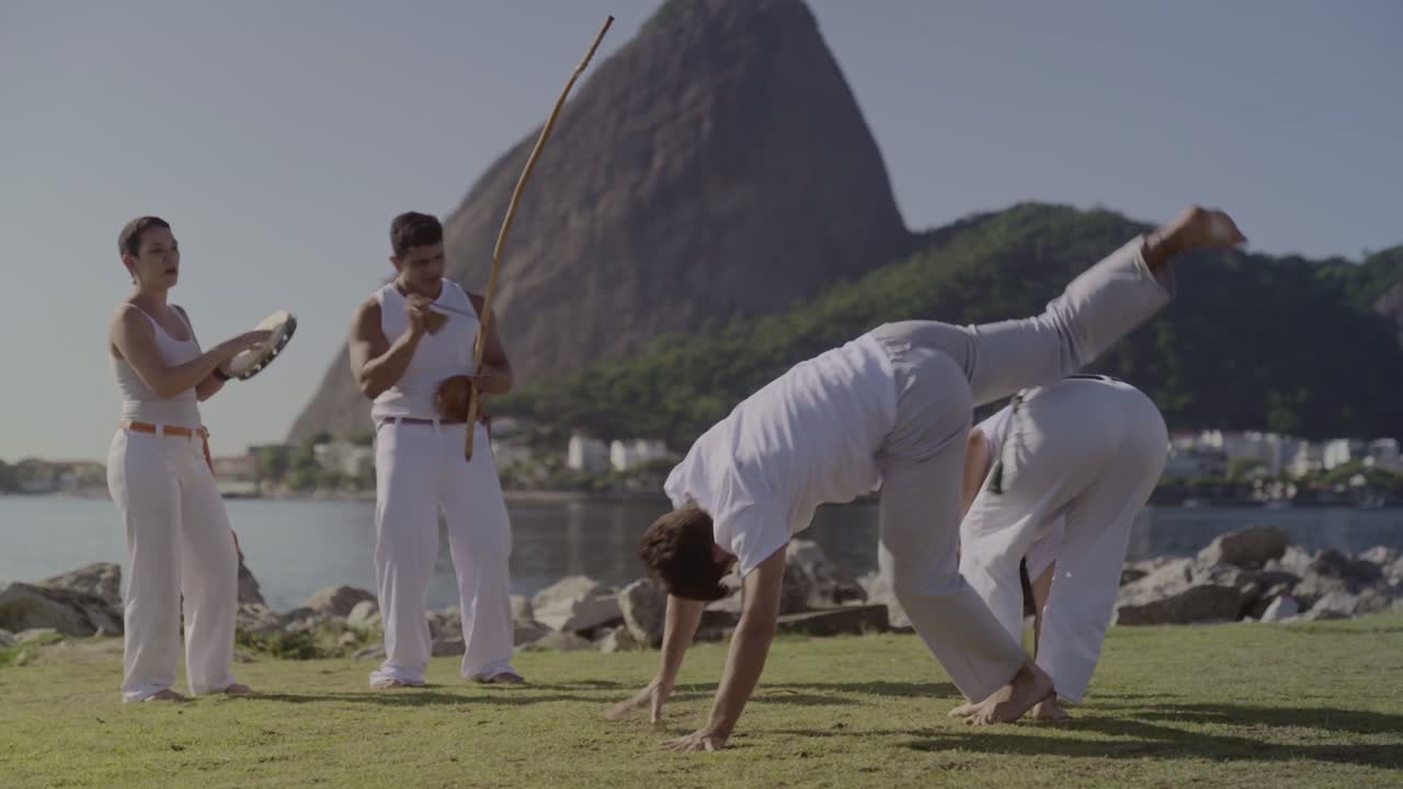 People practicing Capoeira with Sugarloaf Mountain in the background