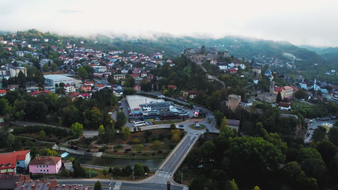 Vista aerea con drone su Jajce che mostra la rotonda centrale, il fiume e la collina della fortezza medievale circondata dal centro storico in Bosnia ed Erzegovina