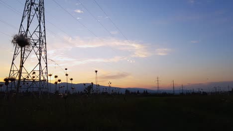 silhouette of high voltage power lines during sunset