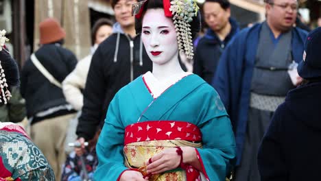 two geishas in traditional attire among spectators