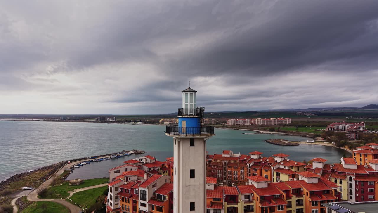 Drone view of a lighthouse overlooking colorful buildings in Bulgaria