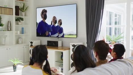 composite of happy family sitting at home together watching baseball game during covid 19 on tv