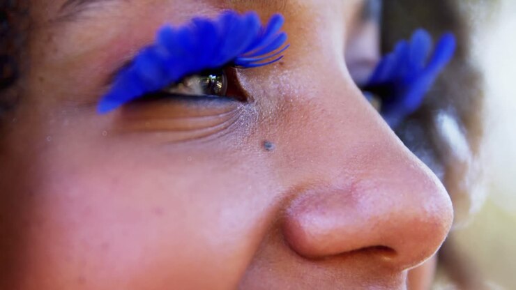 Woman in blue eye lashes at music festival 4k