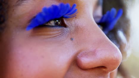 woman in blue eye lashes at music festival 4k