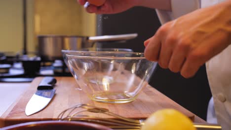 el cocinero empuja el huevo en el bol