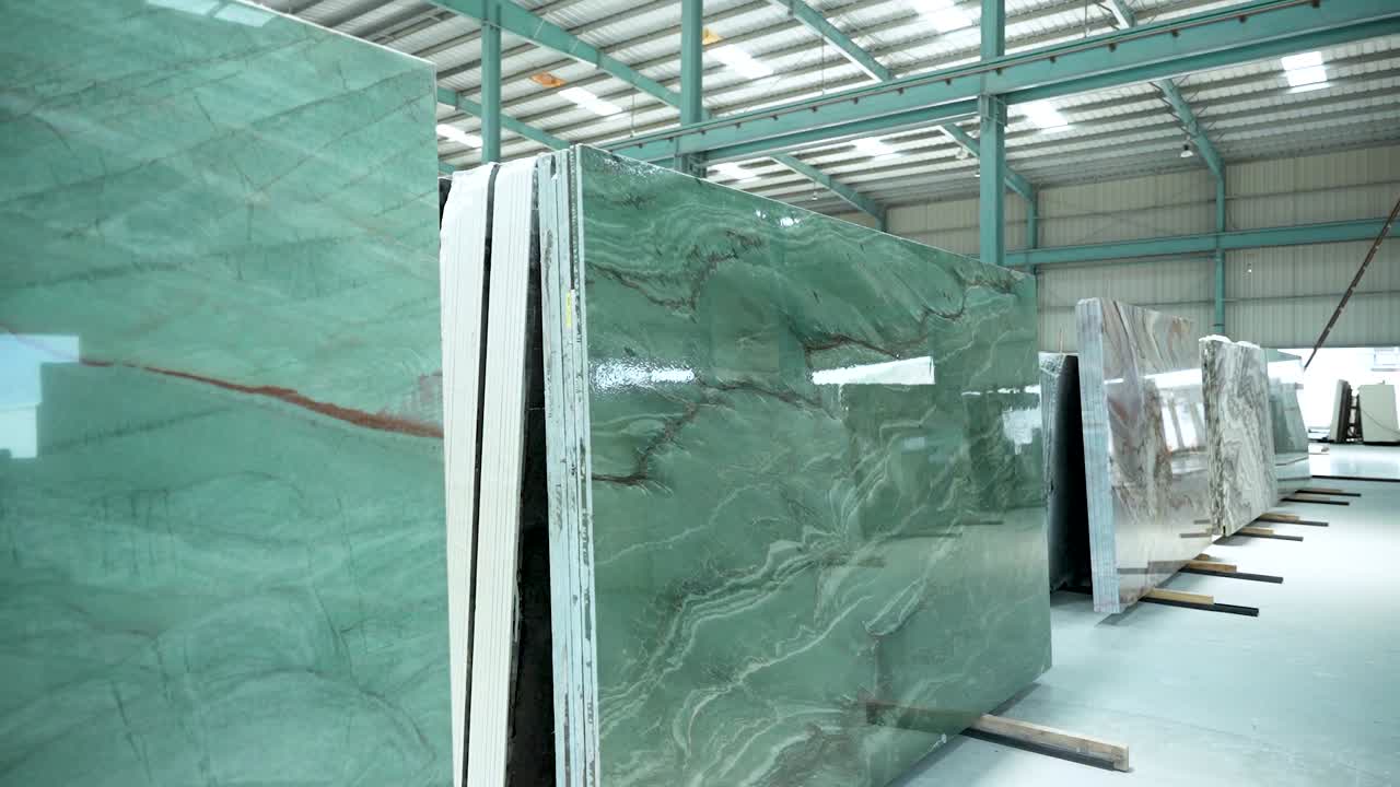 Toma con gimbal de losas de granito y mármol pulido en un almacén moderno, destacando texturas premium, colores vibrantes y durabilidad para interiores de lujo y arquitectura