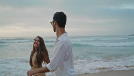 playful pair rejoicing ocean closeup. positive lovers holding hands on sea coast