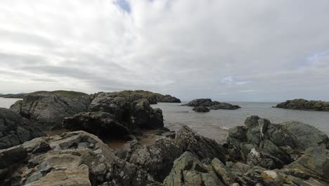 nubes tormentosas y olas de marea del océano lapso de tiempo rompiendo sobre la rocosa costa británica