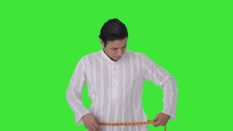 indian man getting sad after measuring waist green screen