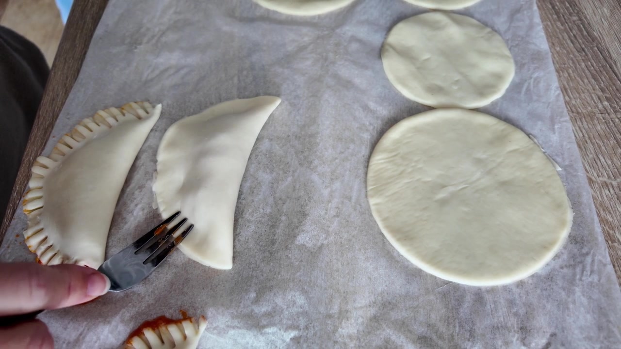 Preparing tuna empanadas at home, hands folding pastry, traditional homemade cooking