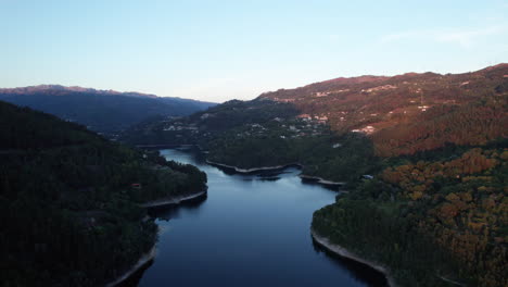 Das-Letzte-Licht-Des-Tages-Fällt-Auf-Einige-Berge,-Die-Einen-Ruhigen-Fluss-Umgeben