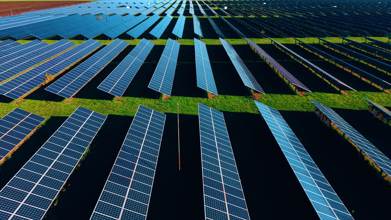 Lunghe celle fotovoltaiche inserite nel campo verde. Scendendo sui pannelli solari rivolti verso il sole