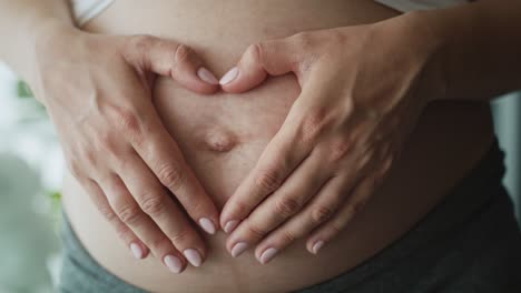 Nahaufnahme-Eines-Herzens-Aus-Händen-Auf-Dem-Bauch.