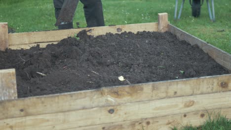 nivelar el suelo en la cama del jardín elevado con pala