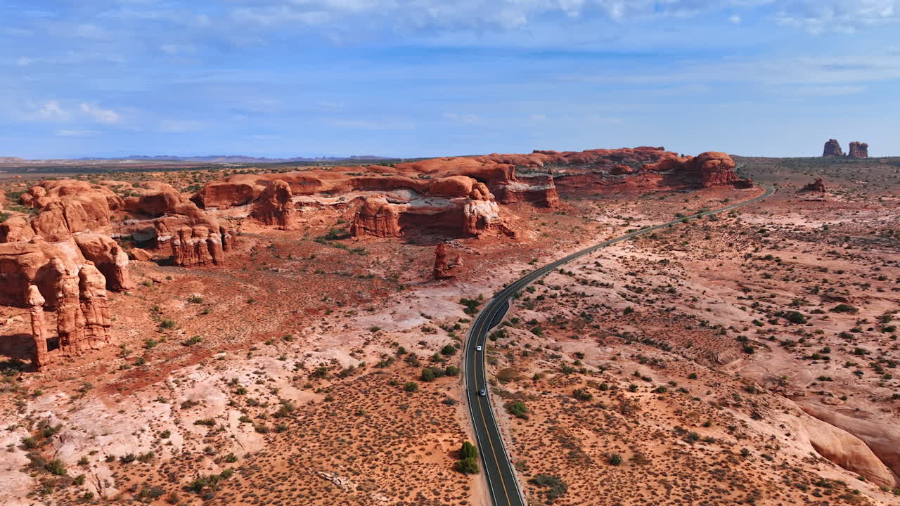 Strada nel deserto tra i canyon di roccia rossa - Arches NP. Vista panoramica di una strada tortuosa attraverso l'Arches National Park, Utah